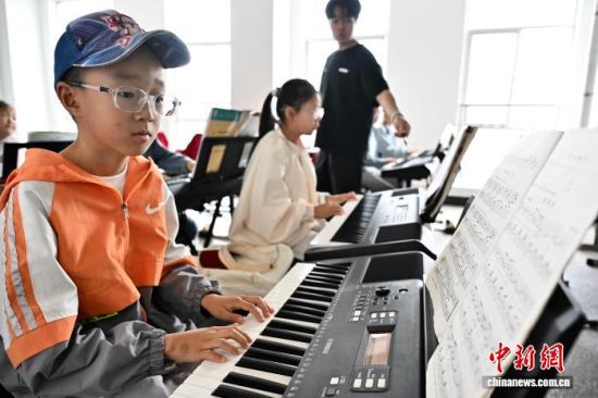 7月18日,宁夏固原市隆德县青少年活动中心,孩子们在老师的指导下学习电子琴。中新社记者 张斌 摄 7月18日,宁夏固原市隆德县青少年活动中心,孩子们在老师的指导下学习电子琴。中新社记者 张斌 摄