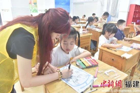 华佳幼儿园的教室内,志愿者指导暑托班学生画画。 高坤颖 摄 华佳幼儿园的教室内,志愿者指导暑托班学生画画。 高坤颖 摄