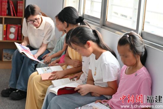 图为实践队员给留守儿童讲故事。三明学院教育与音乐学院供图 图为实践队员给留守儿童讲故事。三明学院教育与音乐学院供图
