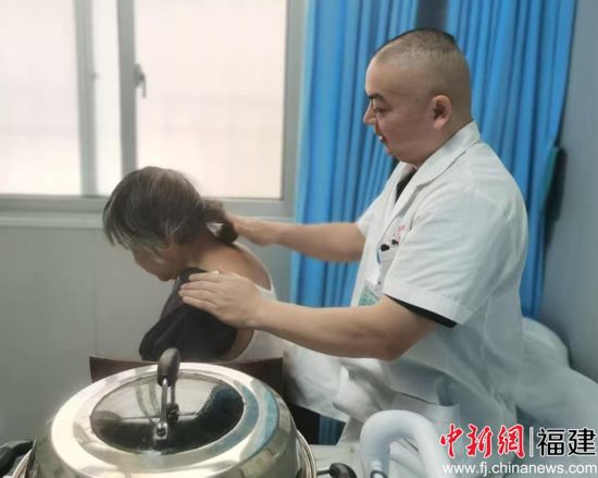 图为管前镇卫生院的医生在给村民做自创的竹筒疗法 图为管前镇卫生院的医生在给村民做自创的竹筒疗法