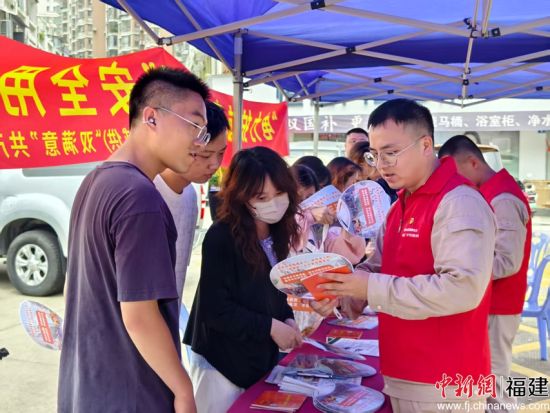 7月30日,国网漳州供电公司新桥供电站站长沈学宇在摊位前为居民普及用电安全知识。林钰芳 摄 7月30日,国网漳州供电公司新桥供电站站长沈学宇在摊位前为居民普及用电安全知识。林钰芳 摄