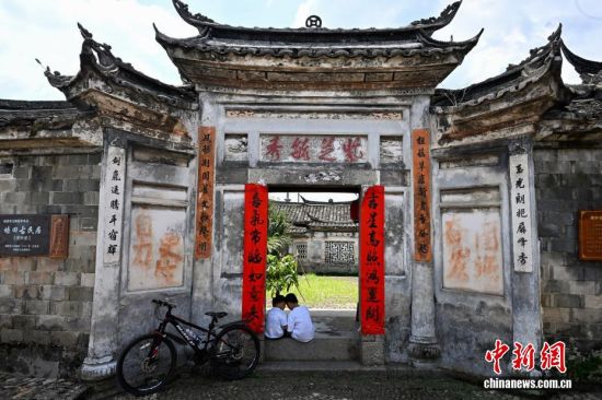 8月8日,福建连城培田古村落里两位小朋友坐在古建筑门槛上玩耍。中新社记者 王东明 摄 8月8日,福建连城培田古村落里两位小朋友坐在古建筑门槛上玩耍。中新社记者 王东明 摄