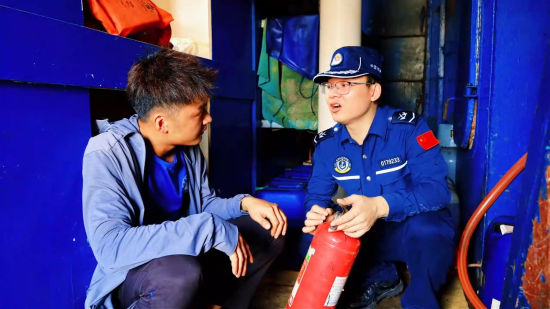 图为海警执法员指导渔民使用灭火器。福州海警局供图 图为海警执法员指导渔民使用灭火器。福州海警局供图