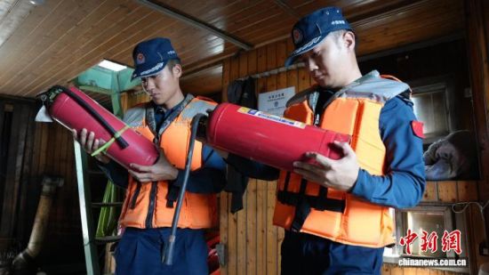 海警执法员登渔船为渔民检查消防设备。蔡晓晔 摄 海警执法员登渔船为渔民检查消防设备。蔡晓晔 摄