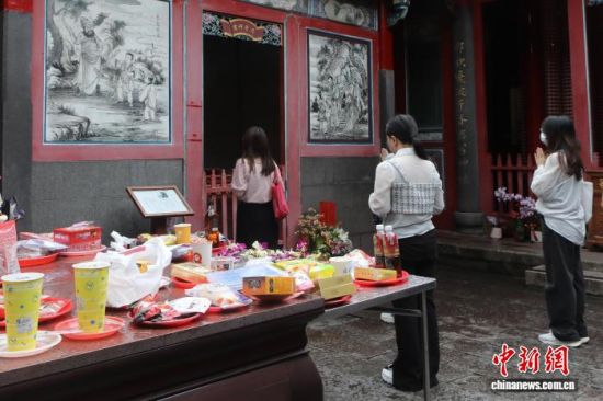 8月19日,台北艋舺龙山寺有大量年轻人前来拜月老。供桌上出现了巧克力、手摇饮。 中新社记者 朱贺 摄 8月19日,台北艋舺龙山寺有大量年轻人前来拜月老。供桌上出现了巧克力、手摇饮。 中新社记者 朱贺 摄