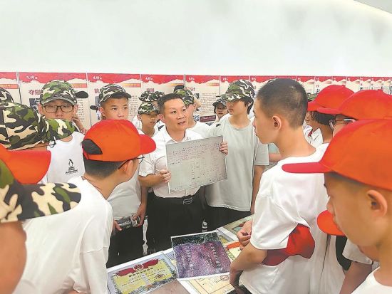 陈文云向师生展示爷爷陈炳寿的烈士登记卡。 (龙岩市退役军人事务局供图) 陈文云向师生展示爷爷陈炳寿的烈士登记卡。 (龙岩市退役军人事务局供图)