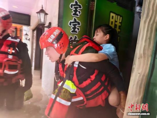 平潭县消防救援大队消防员驰援宁德,背负儿童转移。(平潭县消防救援大队供图) 平潭县消防救援大队消防员驰援宁德,背负儿童转移。(平潭县消防救援大队供图)