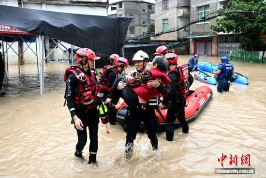 9月3日,福州闽侯县迎来强降雨天气,造成城乡内涝严重,部分居民受困。图为救援人员涉水抱起老人。中新网记者 吕明 摄 9月3日,福州闽侯县迎来强降雨天气,造成城乡内涝严重,部分居民受困。图为救援人员涉水抱起老人。中新网记者 吕明 摄