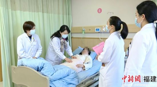 夏泳在病床前轻声询问一位高危孕产妇的恢复情况。受访者 供图 夏泳在病床前轻声询问一位高危孕产妇的恢复情况。受访者 供图