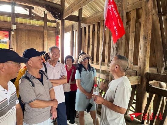在长汀县中复村,红色文化宣讲员向游客讲解“红军桥”的故事。何祖谋 摄 在长汀县中复村,红色文化宣讲员向游客讲解“红军桥”的故事。何祖谋 摄