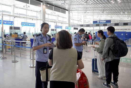 在泉州晋江国际机场出境大厅,民警正在查看旅客证件。董荣超 摄 在泉州晋江国际机场出境大厅,民警正在查看旅客证件。董荣超 摄