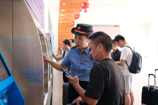 王淼协助旅客购票。黄凌杰 摄 王淼协助旅客购票。黄凌杰 摄