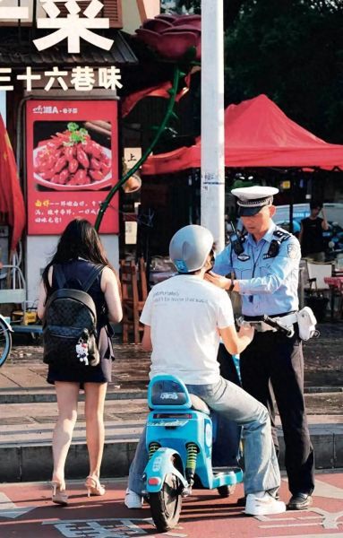 长沙交警帮骑行者系好安全带。 长沙交警帮骑行者系好安全带。