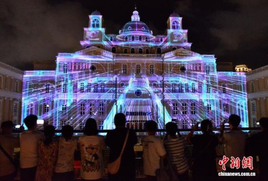 10月1日晚,视觉震撼的光影秀在福州中洲岛的建筑外立面上演,吸引许多民众前来观赏。中新社记者 张斌 摄 10月1日晚,视觉震撼的光影秀在福州中洲岛的建筑外立面上演,吸引许多民众前来观赏。中新社记者 张斌 摄