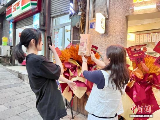 10月6日,食客在品牌门店前拍照留念。中新社记者 钟旖 摄 10月6日,食客在品牌门店前拍照留念。中新社记者 钟旖 摄
