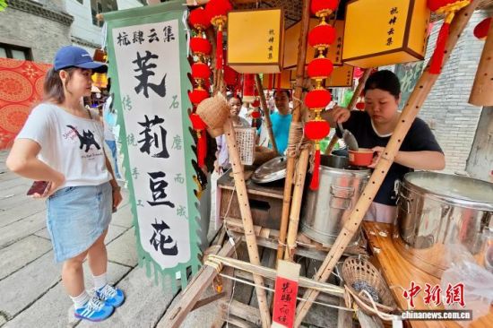 10月2日,福建福州,游客在上下杭古街购买传统手工茉莉豆花。中新社记者 王东明 摄 10月2日,福建福州,游客在上下杭古街购买传统手工茉莉豆花。中新社记者 王东明 摄