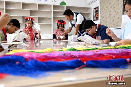 10月9日,国家级非物质文化遗产代表性项目畲族服饰福建省级代表性传承人兰银才(左四)在福建省福州民族小学指导学生学习畲绣。 中新社记者 吕明 摄 10月9日,国家级非物质文化遗产代表性项目畲族服饰福建省级代表性传承人兰银才(左四)在福建省福州民族小学指导学生学习畲绣。 中新社记者 吕明 摄