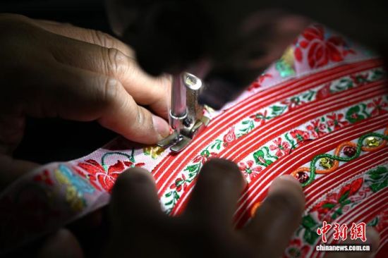10月9日,位于福建省福州市罗源县的福州市畲族服饰传习所里,兰银才正在制作畲族服饰。作为第五代守艺人,兰银才承袭家传手艺,深耕畲族服饰制作,熟练掌握裁剪、车花边等全套传统工序。 中新社记者 吕明 摄 10月9日,位于福建省福州市罗源县的福州市畲族服饰传习所里,兰银才正在制作畲族服饰。作为第五代守艺人,兰银才承袭家传手艺,深耕畲族服饰制作,熟练掌握裁剪、车花边等全套传统工序。 中新社记者 吕明 摄