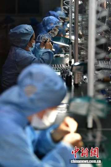 图为工人在生产线上组装镜头。中新社记者 张斌 摄 图为工人在生产线上组装镜头。中新社记者 张斌 摄