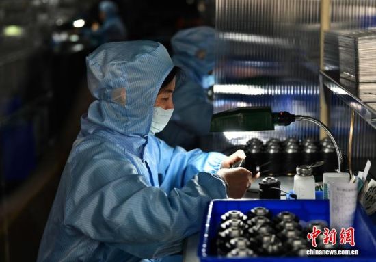 图为工人在生产线上组装镜头。中新社记者 张斌 摄 图为工人在生产线上组装镜头。中新社记者 张斌 摄