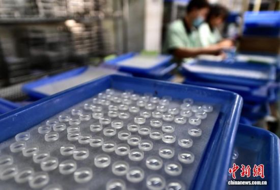 图为工人在镜片生产线上作业。中新社记者 张斌 摄 图为工人在镜片生产线上作业。中新社记者 张斌 摄