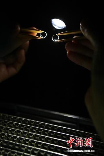 图为工人对生产的镜片进行检测。中新社记者 张斌 摄 图为工人对生产的镜片进行检测。中新社记者 张斌 摄
