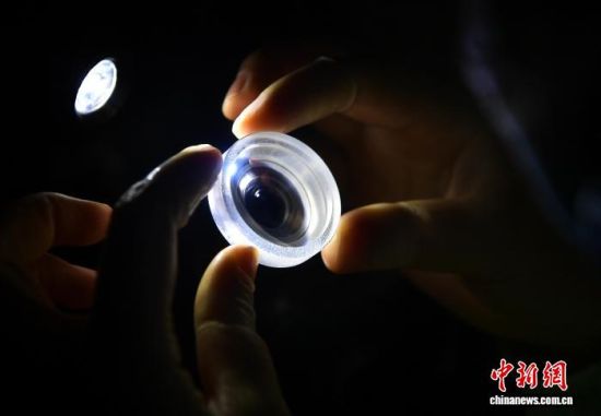 图为工人对生产的镜片进行检测。中新社记者 张斌 摄 图为工人对生产的镜片进行检测。中新社记者 张斌 摄