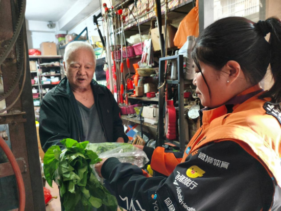 图为骑手顺便帮老人带菜。陈美玲 摄 图为骑手顺便帮老人带菜。陈美玲 摄