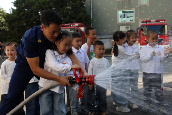 消防员现场带领孩子体验灭火。 受访者供图 消防员现场带领孩子体验灭火。 受访者供图